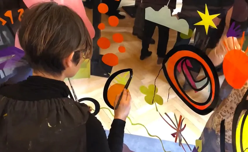 Participants engagés dans la création d'une fresque collective colorée lors d'un team building à Lyon.