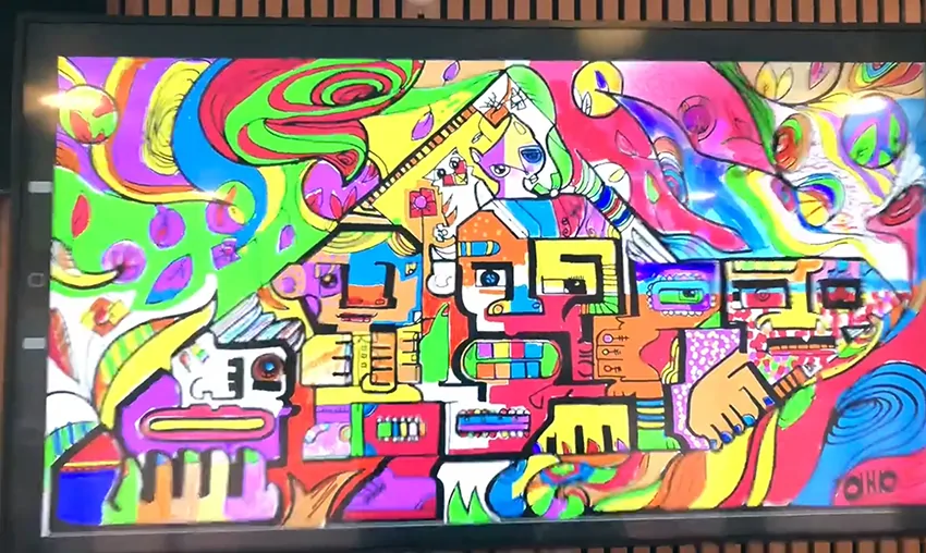 Une œuvre numérique colorée composée de multiples dessins superposés lors d'une performance d'aNa artiste.