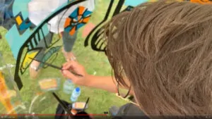 aNa Fernandes en train de créer la géniale Animation Anniversaire Entreprise fresque plexiglass éco-responsable imaginée par My Art Box à Bourg-en-Bresse en extérieur