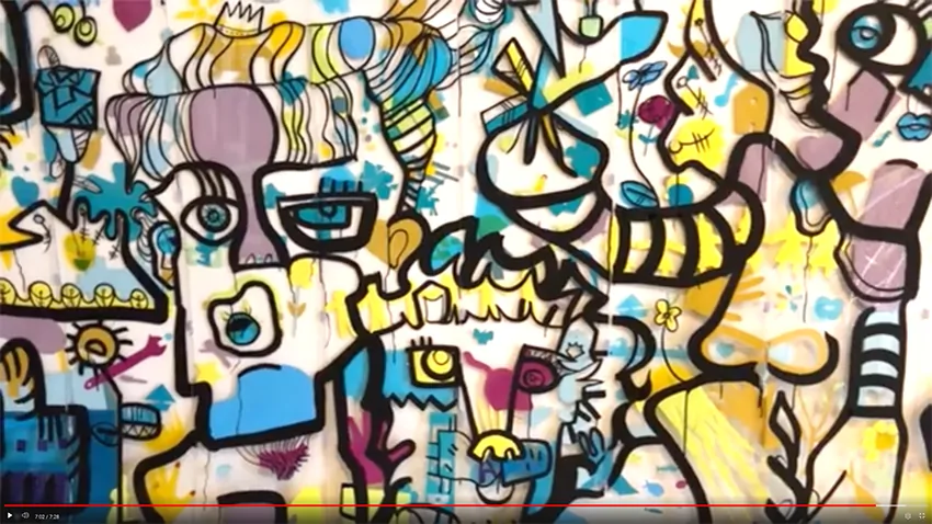 Gros plan sur une œuvre collective colorée peinte sur un support transparent en plexiglas lors d'un séminaire.