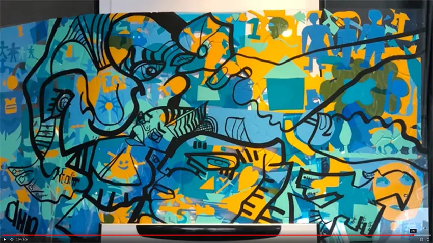 Grande fresque colorée finalisée lors d'un atelier de cohésion d'équipe avec des participants engagés.