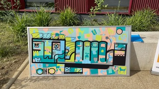 Grande œuvre collective colorée et encadrée lors d'une inauguration à Argenteuil.