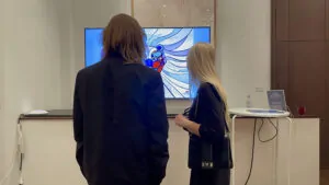 Un couple admire la fresque digitale livre d'or artistique projetée en direct sur un écran