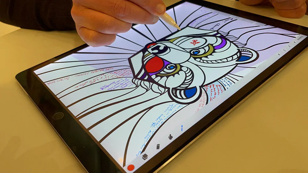 Une jeune femme signe la fresque digitale livre d'or artistique en cours de création et projetée sur un écran en même temps pour être suivie des autres invités