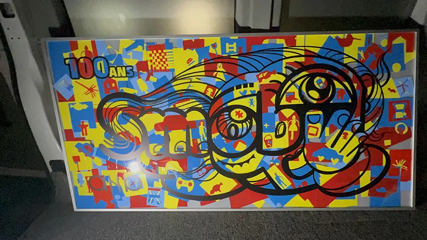 La fresque des jouets imaginée par ana artiste pour l'anniversaire des 100 ans de Smoby à Lons Le Saunier une fois terminée avec les invités participants et encadrée