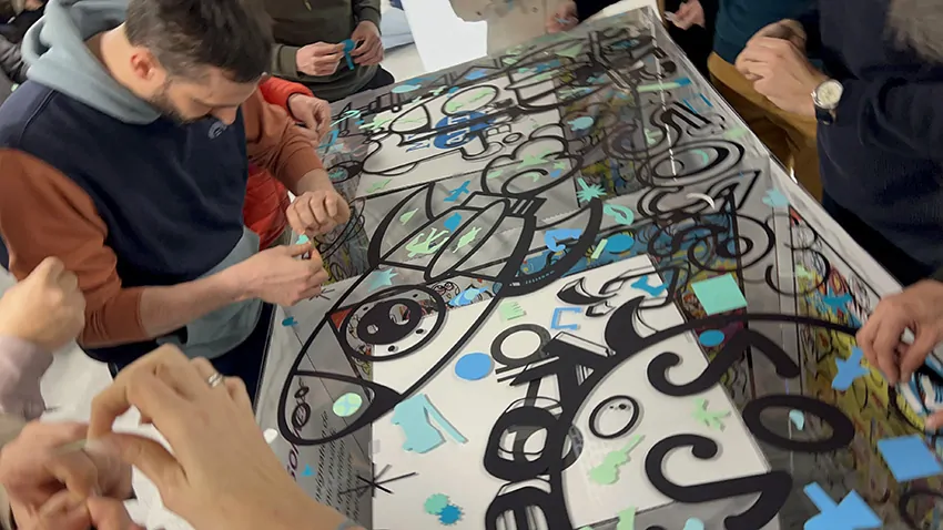 Les participants d'une équipe lors d'une animation team building autour du plexi sur la fresque de la frugalité My Art Box à Grenoble