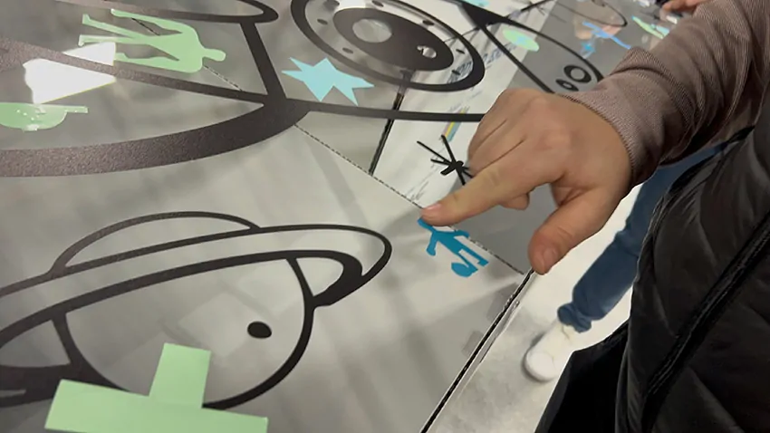 Un joueur de foot découpé par un participant à la fresque de la frugalité My Art Box à Grenoble