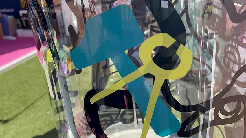 Symboles d'outils découpés dans du vinyle coloré apposés sur un support transparent en plexiglas.