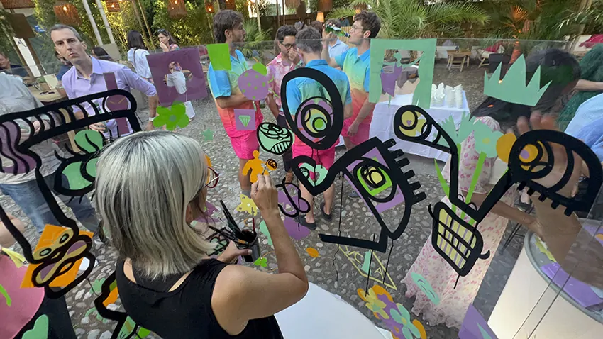 La street artiste ana collabore avec 200 personnes lors de l'animation ludique fresque en garden party à Genève