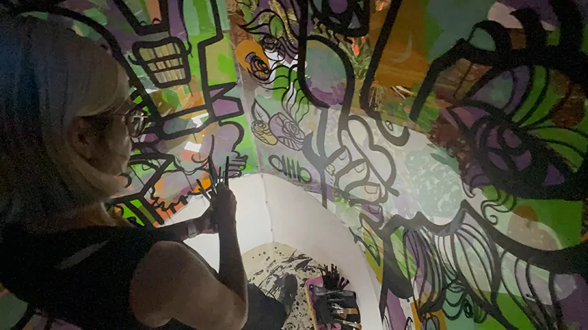 ana artiste signe sa fresque en garden party collaborative en fin de soirée dans son tube plexi éco responsable à Genève