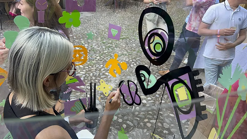 Ana artiste crée une œuvre en triptyque lors d'une animation éco-responsable de fresque en garden party à Genève