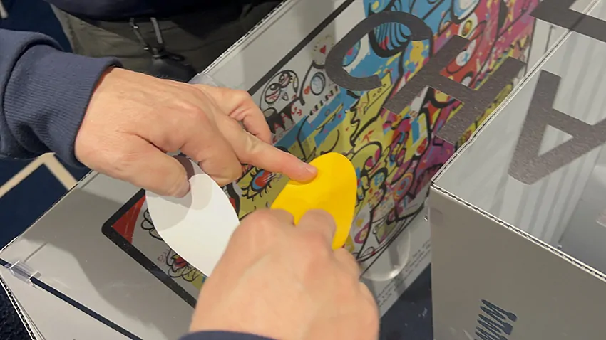 Un participant colle son idée découpée dans le vinyle de son kit individuel sur la fresque My art box en animation marque employeur pour managers à Dunkerque