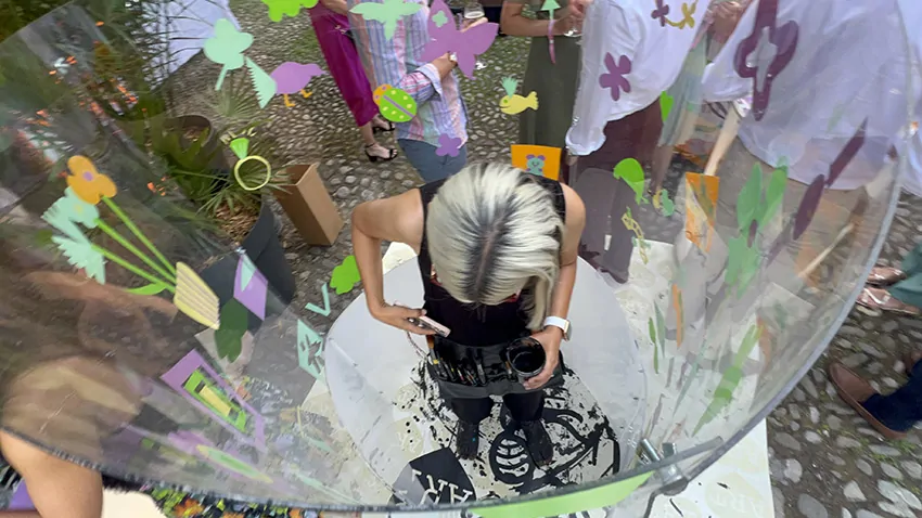 Idée d'animation éco-responsable fresque en garden party à Genève avec aNa artiste en live painting dans son tube plexi et les participants tout autour en même temps