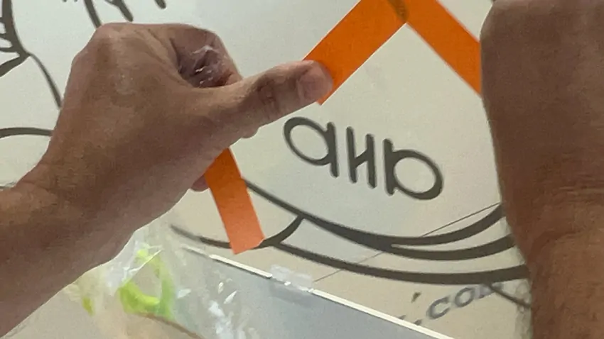 Le collage d'un sticker orange sur le plexi collectif par un participant lors d'une animation team building fresques en équipes à Lyon