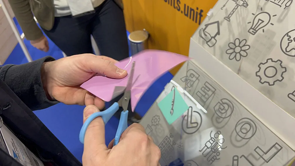 Un participant découpe son idée dans du vinyle adhésif en animation fresque sur stand de salon éco-responsable à Lyon ou Paris