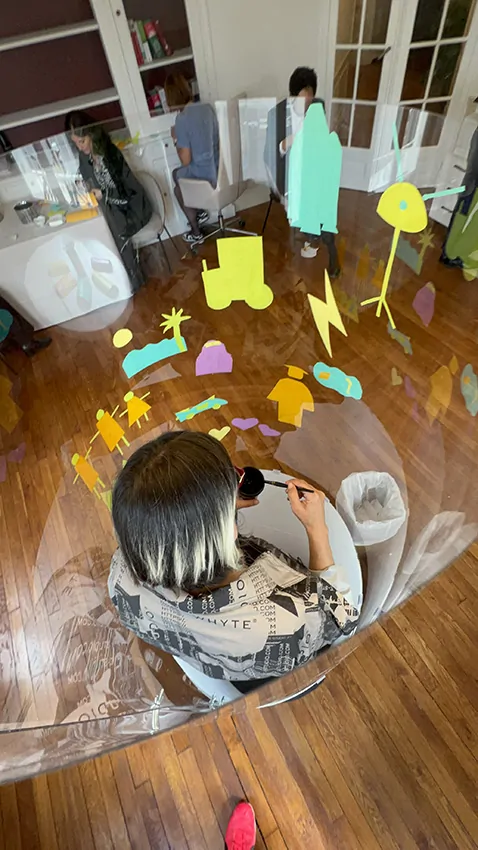 ana artiste crée en Live dans son tube plexi transparent en team-building pour avocats éco-responsables à Paris organisé par My Art Box