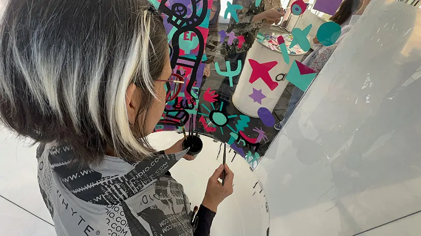 ana artiste en train de peindre dans son tube plexi éco-responsable recyclable une fois lors du team building secteur de la petite enfance à Genève