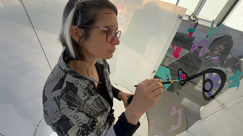 ana artiste est concentrée et peint dans son tube plexi rse lors du team building secteur de la petite enfance à Genève organisé par My Art Box et animé par Christophe Chazot