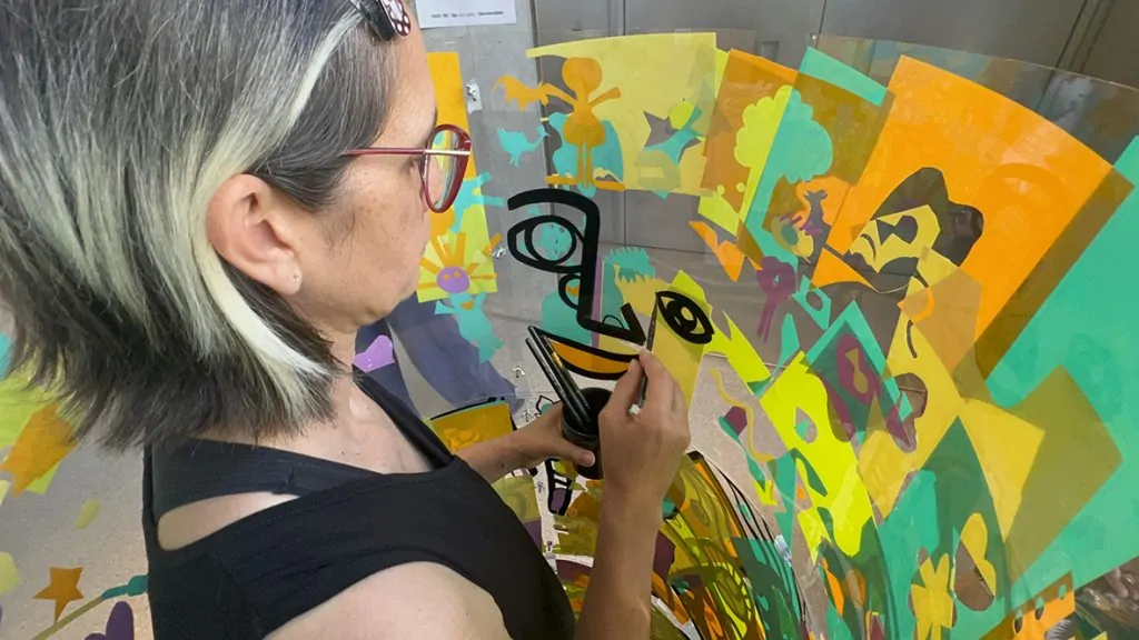 ana artiste dans son cylindre plexi recyclable en animation fresque éco-responsable à Genève à la Comédie