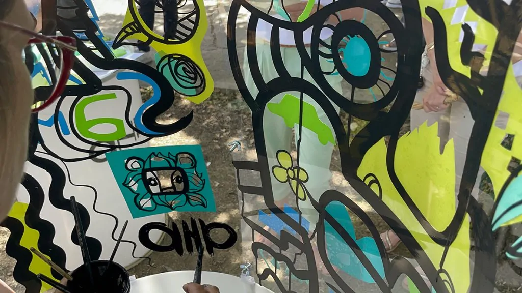 My Art Box propose une super idée d'animation ludique fresque en garden party à Grenoble réalisée par aNa qui est dans un cylindre transparent en train de peindre pendant que les participants découpent et collent leurs idées depuis l'extérieur pour apporter de la couleur