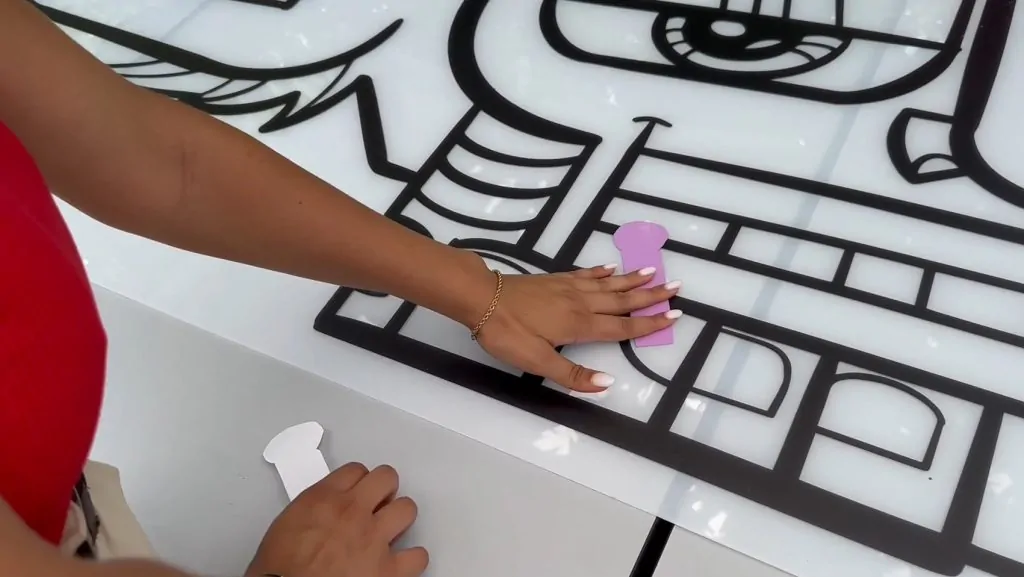 Une participante à la fresque œuvre collective éco-responsable à Montpellier colle son idée sur le plexi