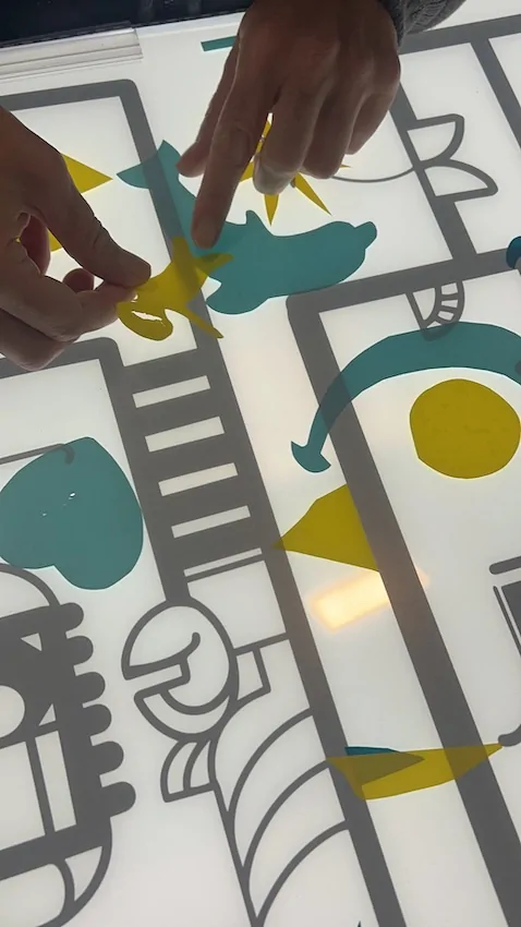 Un symbole d'un enfant en vinyle jaune découpé et collé sur le dos d'un dauphin pour la fresque zen de Cluny en cours de construction