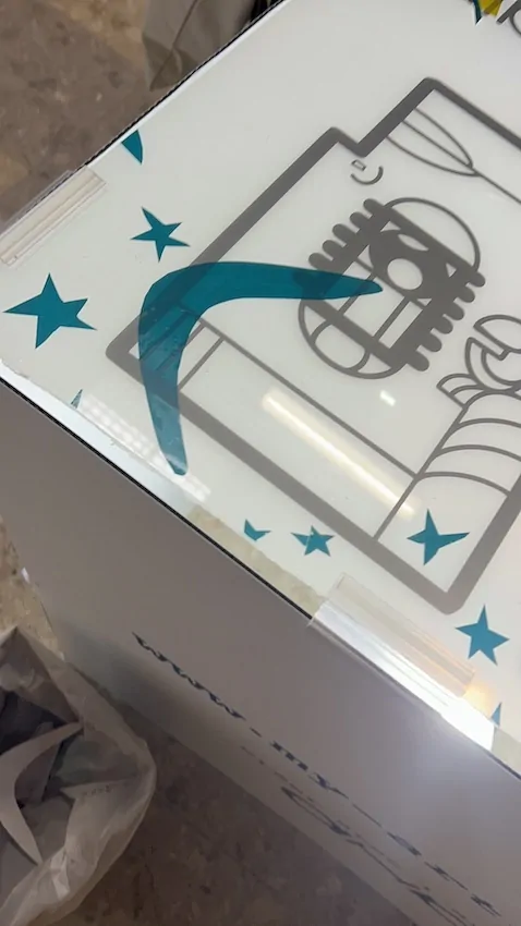 Des étoiles en vinyle bleu découpées et collées sur la fresque zen de Cluny en cours de construction