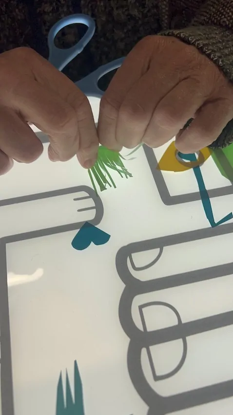 Un brin d'herbe verte découpé dans du vinyle du kit créatif My Art Box pour la fresque zen de Cluny