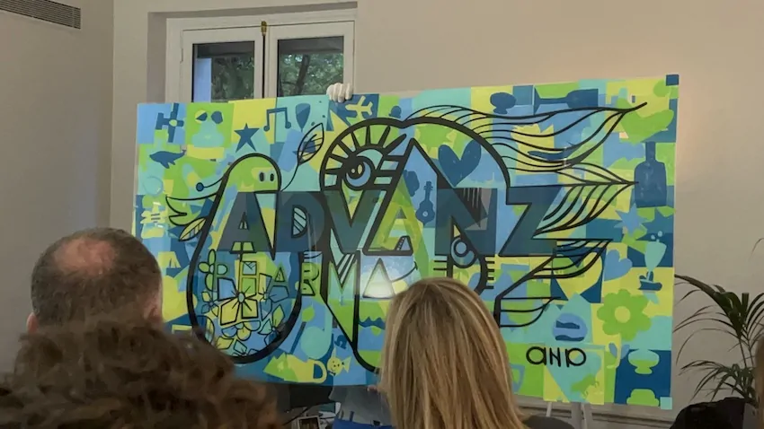 Participants découvrant une grande fresque colorée représentant un logo éco-responsable lors d'un événement à Paris.