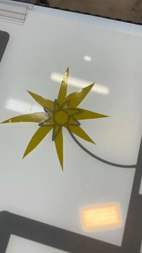 Un symbole de soleil en vinyle jaune découpé par une participante à la fresque zen de Cluny